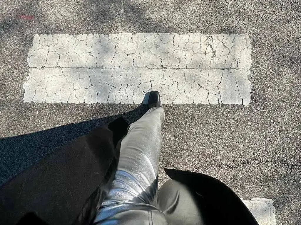 Person stepping across a crosswalk symbolizing progress and the transition into the future of AI search